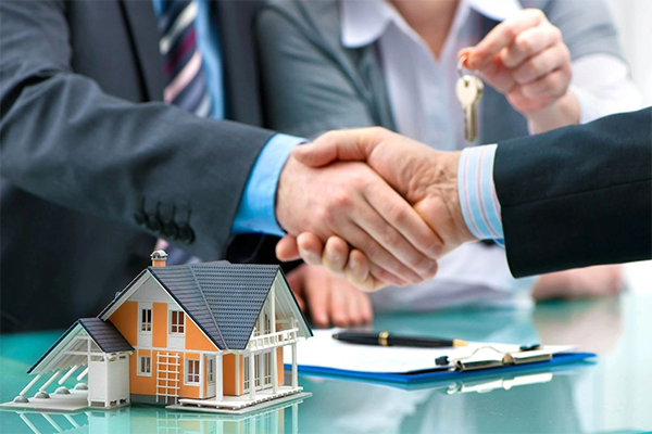 Estate agent shaking hands with customer after contract signature